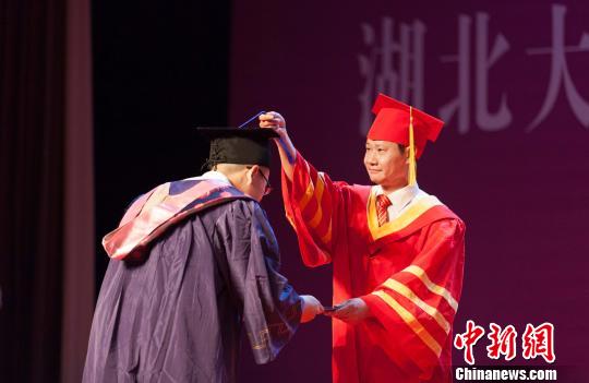 图为,湖北大学校长赵凌云为毕业生拨穗正冠 向正鹏 摄 图为,湖北大学校长赵凌云为毕业生拨穗正冠 向正鹏 摄